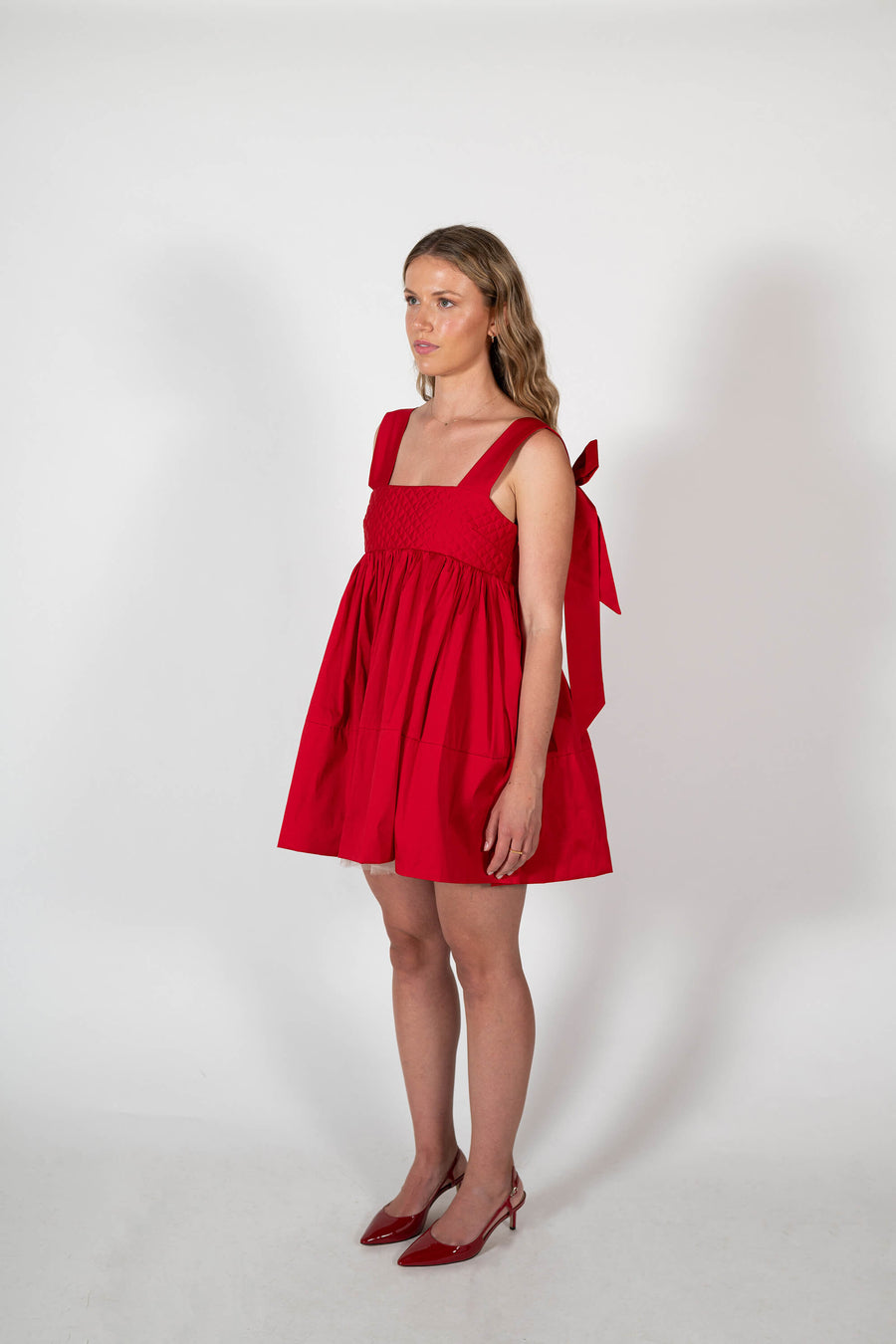 Angled view of the signature Dolly Mini dress in Red by House of Campbell.